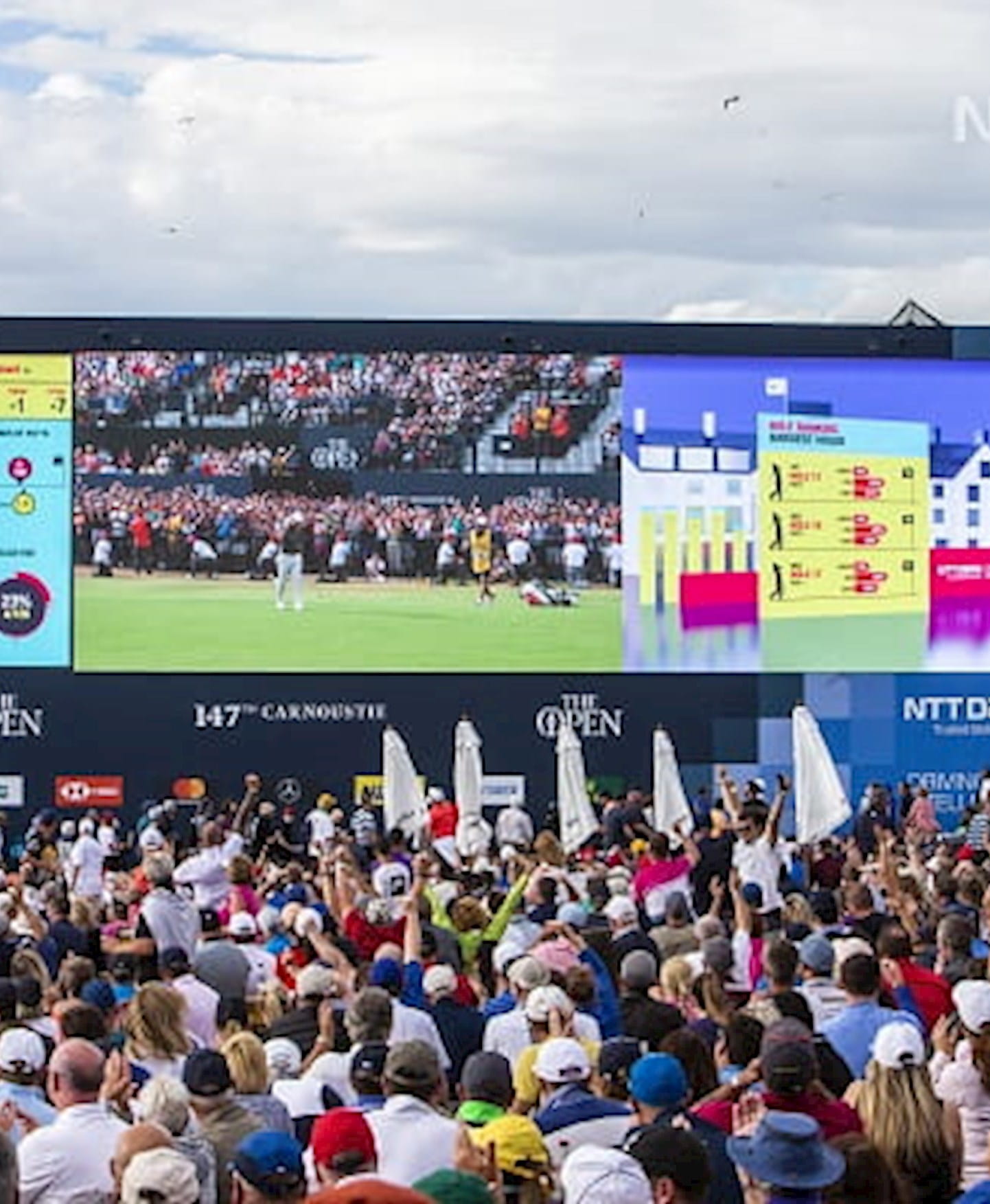 a crowd of people watching a large screen