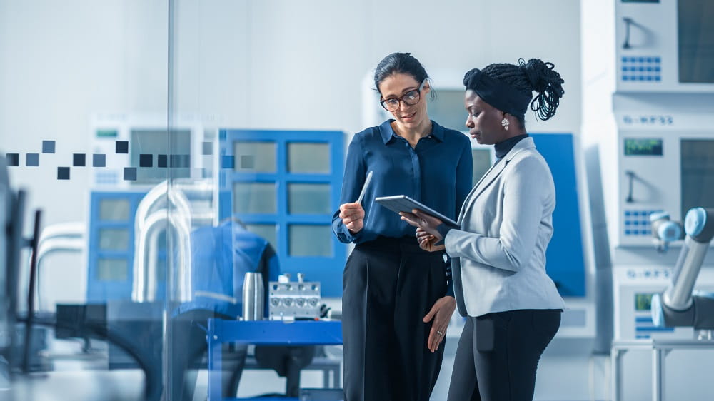 two business women talking in a factory