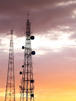 a group of telecommunication towers at sunset