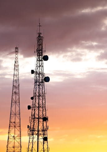 a group of telecommunication towers at sunset